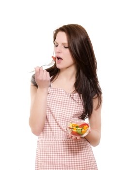 young woman eating salad. young beautiful woman eating salad with a fork on white background