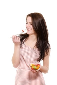 laughing woman eating salad. happy young woman with red apron eating salad on white background