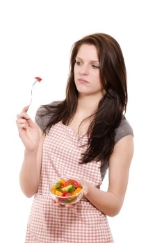 young woman is suspicious about the salad. young woman is suspicious about the salad on her fork with white background