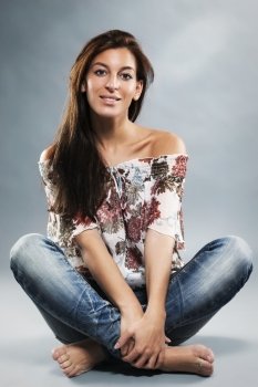 young woman wearing blue jeans sitting on the floor. young woman wearing blue jeans sitting on the floor in taylor seat