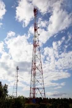 Cell tower  in  forest  against the background of blue sky