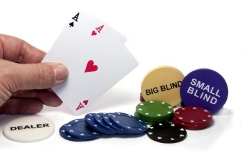 hand with two aces during poker game with chips on isolated white