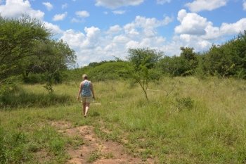 woman walking en enjoy  nature with bleu sky and white clouds in africa