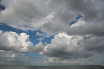 cloudscape above lake with boats
