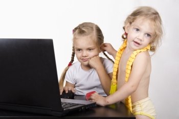 Image of a business girl. The girl sitting at the table. On the table is a laptop, girl it works. Suddenly in the CR ran another girl and took the ear first girl