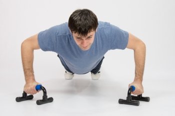 thirty young athletic man does physical exercises. Tired athlete is pushed on supports