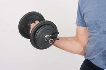 thirty young athletic man does physical exercises. Hand athlete with dumbbell