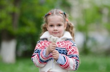 Portrait four-year girl with bouquet white dandelions in the hands of. Half-length portrait four-year girl in a jacket with a bouquet of dandelions in the hands of
