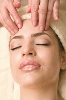 Young beautiful woman having facial massage.