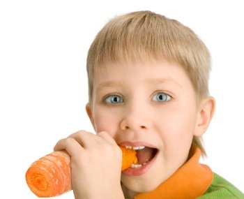 Happy little boy biting a carrot