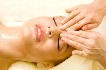 Young beautiful woman having facial massage.