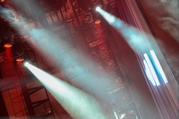 Concert spotlights shining red light and fog