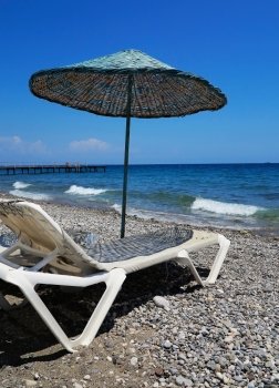 Chaise lounge under an umbrella on the beach, Kemer, Turkey