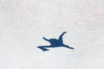 shadow of a man jumping on the asphalt