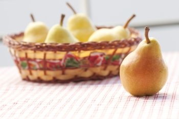 pears in a wooden basket  lying on a plaid fabric 