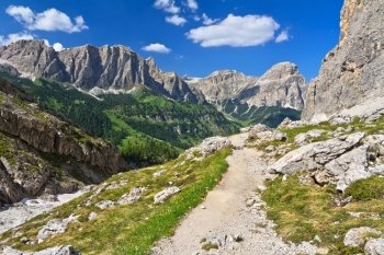footpath in high Badia Valley, on background Sassongher mount, Alto Adige, Italy