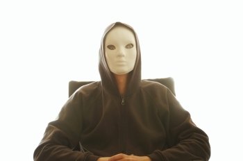 Man with white mask sitting on a chair. Backlit spooky male figure silhouette.