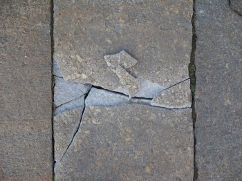 Broken stone. Cracked stone in a pavement