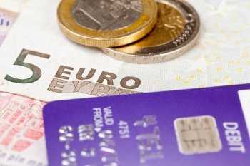 Macro of debit card and on top of euro note to illustrate currency crisis in Europe