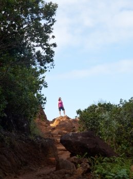 Single woman walker on summit of Kalalau trail along Na Pali coast in Kauai Hawaii