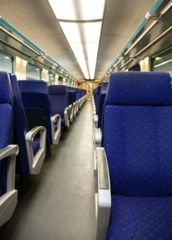 Interior of railroad coach with perspective of empty blue seats