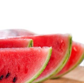 fresh ripe watermelon sliced on a  wood table over white background