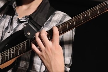 The guitarist plays on a guitar shooting closeup