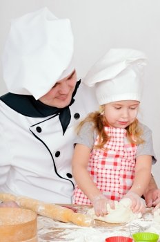 Chef teaches girl to knead the dough