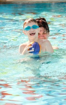 happy mother and son playing in the pool
