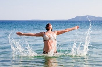 happy woman in sea water splashes