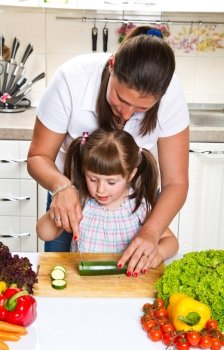 Mother and daughter in kitchen preparing vegetables