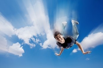 Boy is falling through the clouds while showing funny face