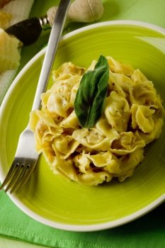 delicious italian fresh tortellini with butter and sage on green wooden table 