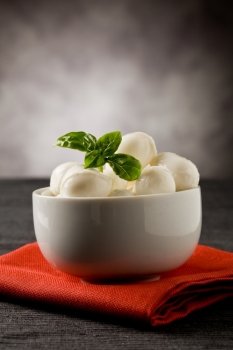 photo of delicious small mozzarella cherries with basil inside a bowl 