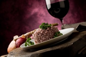 photo of delicious risotto with red wine on wooden table 