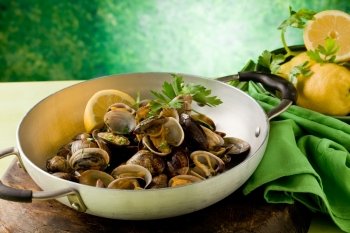 photo of delicious clams inside a pan in front of a greeb background