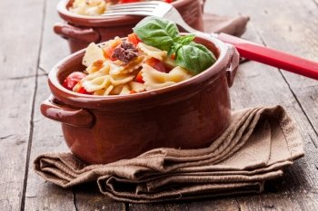 photo of delicious pasta with cherry tomatoes and olives on wooden table