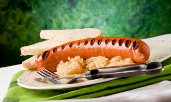 photo of delicious grilled hot dog with sauerkraut and bread,