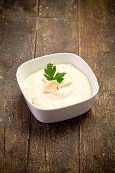 homemade cheese sauce with parsley leaf on wooden table