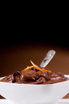 delicious chocolate mousse inside a white bowl with orange zest