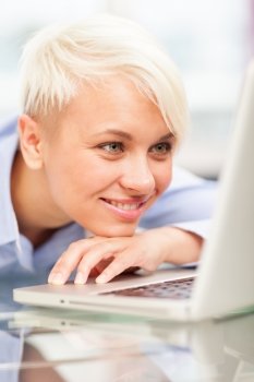 photo of woman relaxing in front of her computer while smiling