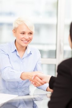Handshake between businesswomen in the office