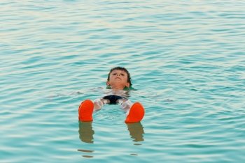 The boy lies on the water from the Dead Sea