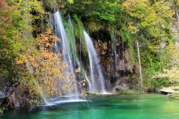 Scenic waterfall and small lake in the autumn mediterranean forest