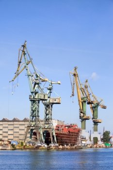 Industrial scenery, huge shipyard cranes and ship under construction