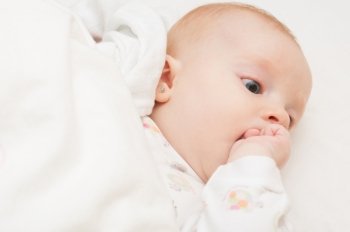 Baby Lying on Back Sucking its Hand