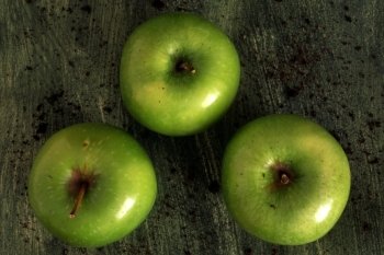 Three green apples isolated on painted background