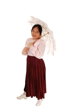 An Asian woman in old fashioned clothing standing for white backgroundand holding an embroidered sun-umbrella wearing a long burgundy skirt.