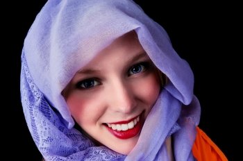 A beautiful young woman with blue eye’s and a blue scarf around herhead, isolated for black background.