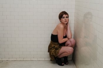 Pretty redhead posing in an old men’s room